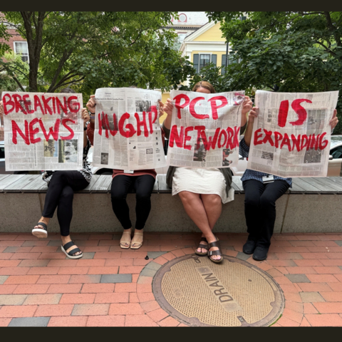 Four people hold newspapers painted with large red words, including “BREAKING NEWS, HUGHP PCP NETWORK IS EXPANDING.”