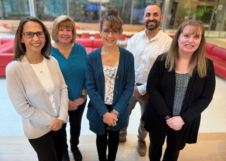 Member Services standing and smiling inside the Smith Campus Center