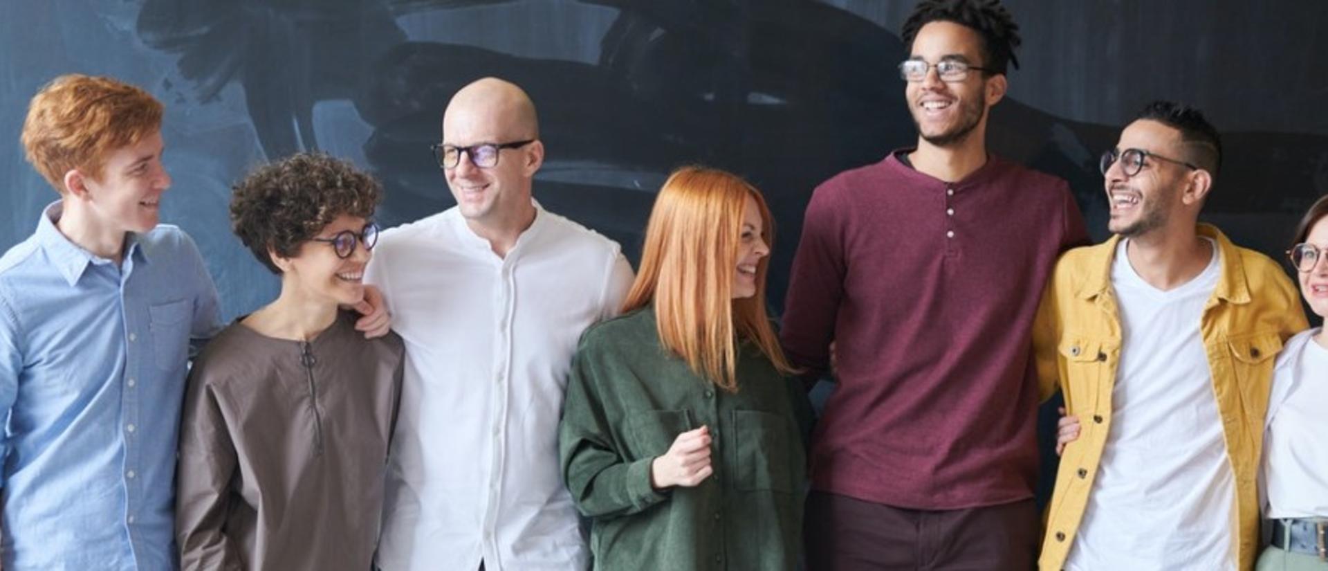 Group of people standing beside each other in front of a chalkboard