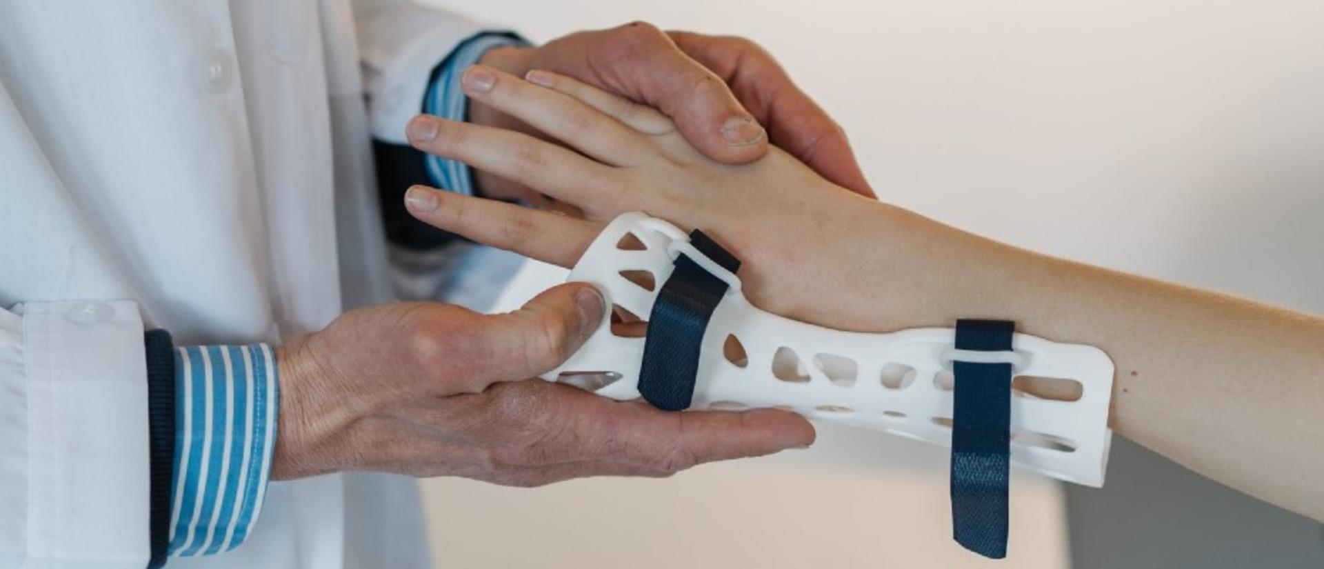 Doctor fitting a splint to a patient's wrist.